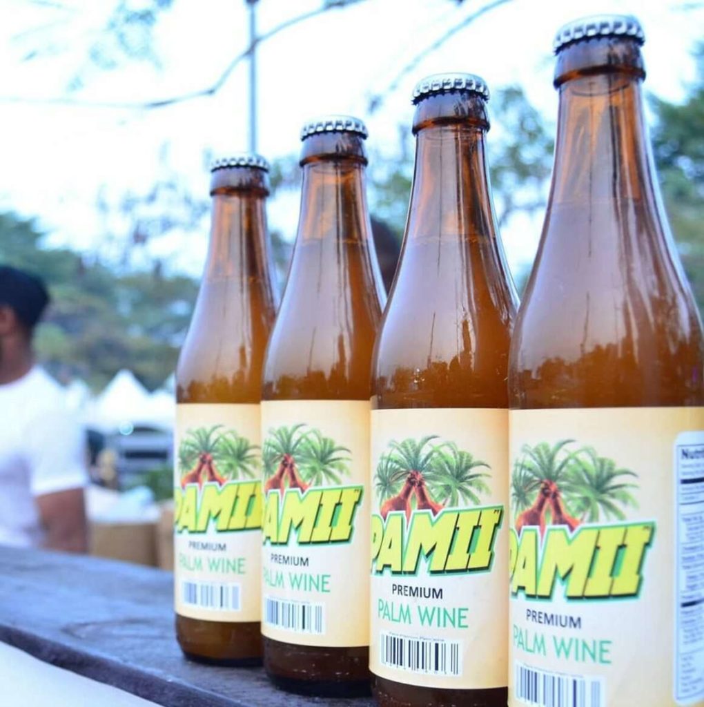 Four bottles of of Pamii brand palm wine lined up on a counter.